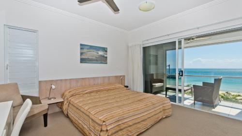 a bedroom with a bed and a view of the ocean at Deep Blue Apartment 20 Tangalooma in Tangalooma