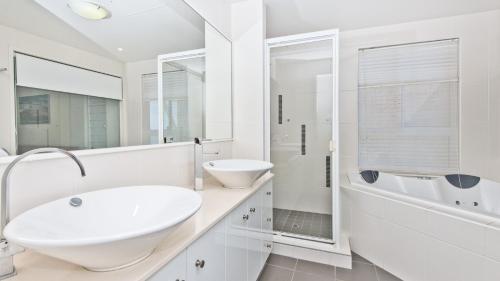 a white bathroom with a sink and a mirror at Deep Blue Apartment 20 Tangalooma in Tangalooma