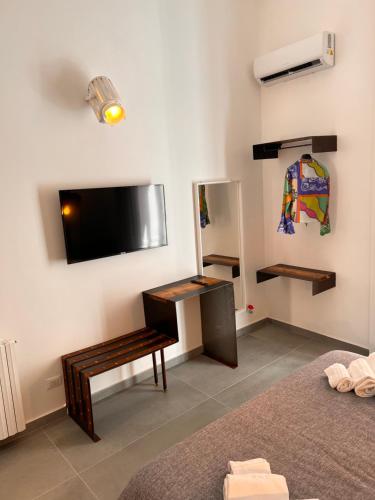 Habitación con cama, escritorio y TV. en Welcome Catania, en Catania