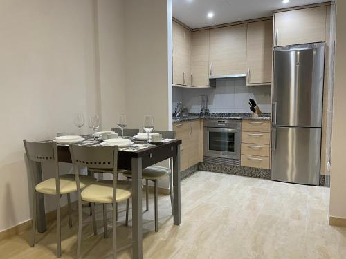 a kitchen with a table with chairs and a refrigerator at Apartamento vistas al mar in Viveiro