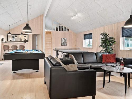 a living room with a couch and a pool table at 24 person holiday home in Hasselberg in Kappeln