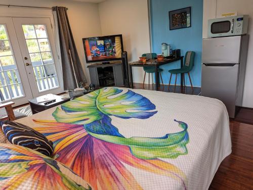 a colorful blanket on a bed in a room at Hilo Luxury Suite in Hilo