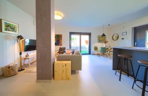 un soggiorno e una cucina con divano e tavolo di Apartments Sol a Njivice