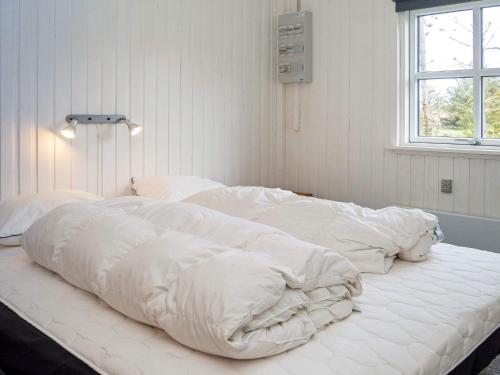 a large bed with white sheets and a window at 6 person holiday home in Thisted-By Traum in Thisted