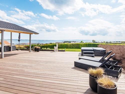 a patio with chairs and a view of the ocean at 6 person holiday home in R nde in Rønde