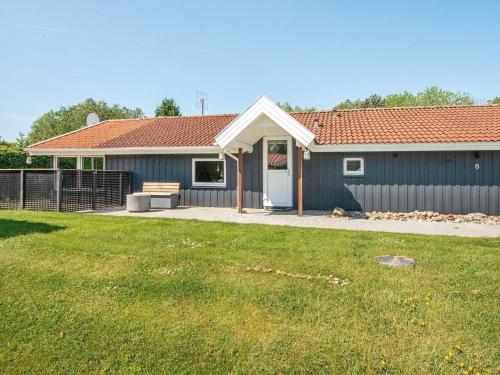 a blue house with a grass yard in front of it at 8 person holiday home in Hejls in Hejls
