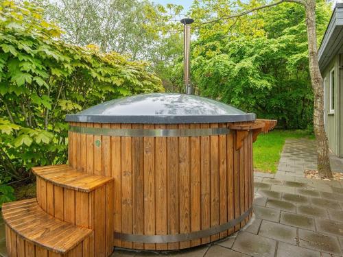 a wooden hot tub with two benches in a yard at 6 person holiday home in Hemmet in Hemmet