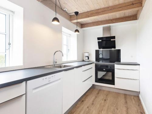 a white kitchen with white cabinets and a sink at 6 person holiday home in Faaborg-By Traum in Fåborg