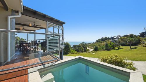 a house with a swimming pool and a patio at Ohana Beach House in Tangalooma
