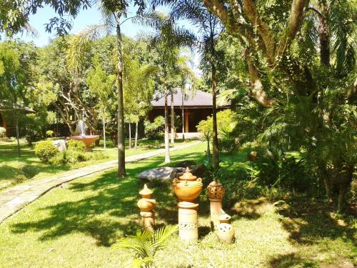 a garden with several vases sitting in the grass at Huan Chiang Dao Resort in Chiang Dao
