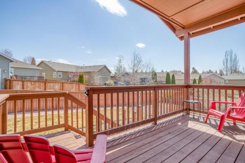 a deck with red chairs and a wooden railing at Hunters Circle - Meredith Lodging in Bend