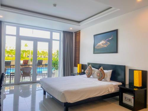 a bedroom with a bed and a view of a pool at Riverside White House Hotel in Hoi An