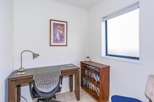 a desk and a chair in a room with a window at Self Contained Cottage Pukekohe in Auckland