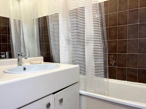 ein weißes Bad mit einem Waschbecken und einer Dusche in der Unterkunft Appartement Le Lavandou, 1 pièce, 3 personnes - FR-1-251-420 in Le Lavandou