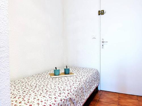 einem Tisch mit zwei blauen Tassen auf einem Bett in der Unterkunft Appartement Le Lavandou, 1 pièce, 3 personnes - FR-1-251-420 in Le Lavandou