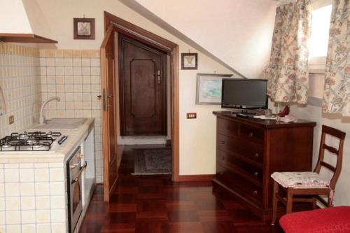 kuchnia z kuchenką i telewizorem na komodzie w obiekcie B&B Domus Gratiae w mieście Ostia