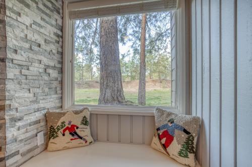 asiento junto a la ventana con 2 almohadas de Navidad en un porche en Ski House 154 - Meredith Lodging, en Bend