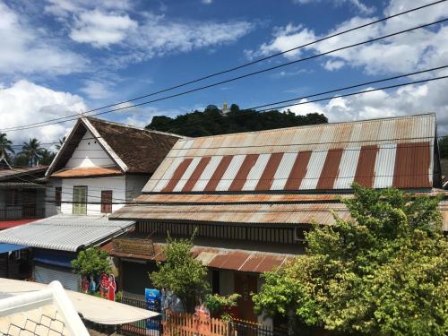 an old building with a rusty metal roof at Mali House in Luang Prabang