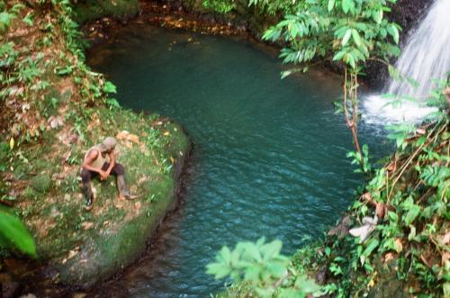 a man is standing next to a river at Lodge El Amargal - Reserva Natural, Ecoturismo & Surf in Nuquí