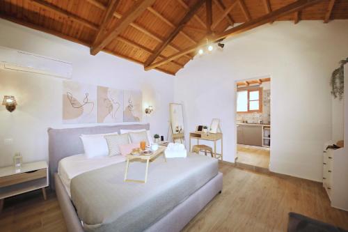 a bedroom with a large bed and a table at Dafnes in Skopelos Town