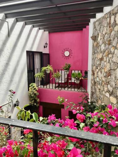 a pink building with tables and chairs and flowers at Villa Sueño Azul B&B in Guanajuato