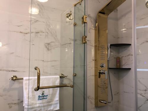 a shower with a glass door in a bathroom at Lazorde Beachfront Experience in El Alamein