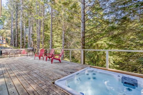 a hot tub on a wooden deck with chairs and trees at Dune With A View in Lincoln City