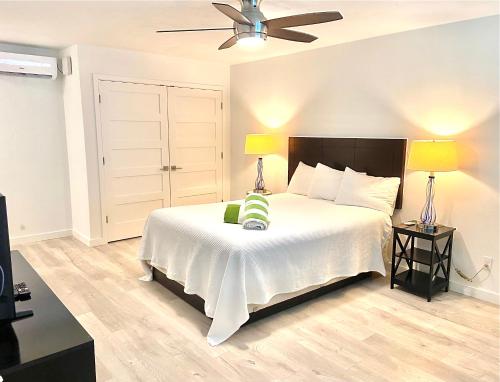 a bedroom with a bed with a ceiling fan and two lamps at Organic Beach Retreat in Daytona Beach