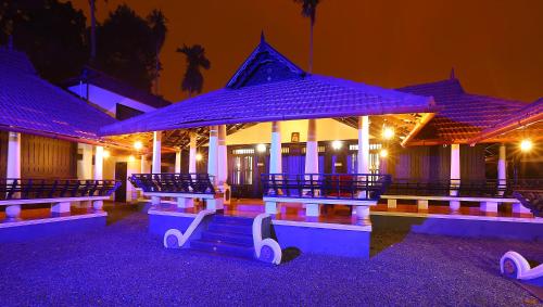 un bâtiment avec des lumières violettes devant lui la nuit dans l'établissement Palmy Lake Resort, à Alappuzha