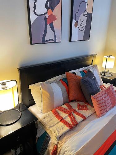 a bedroom with a bed with pillows and paintings at Flat Bush Holiday Accomodation in Auckland