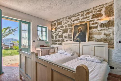two beds in a room with a stone wall at Villa Sancta Maria in Motovun