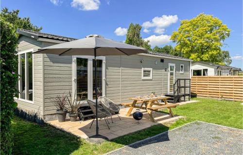 a patio with an umbrella and a table and chairs at Stunning Home In Heinkenszand With Wifi in Heinkensand
