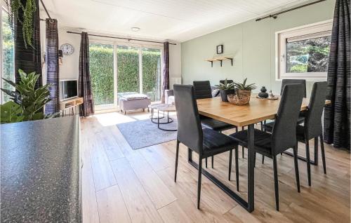 a kitchen and dining room with a wooden table and chairs at Stunning Home In Heinkenszand With Wifi in Heinkensand