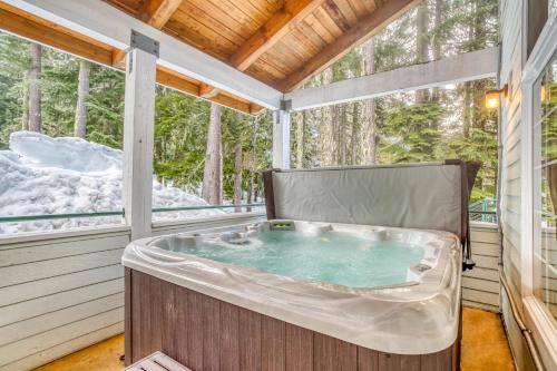 Una bañera de hidromasaje en un porche con ventanas. en The Chinook Lodge at Government Camp - Meredith Lodging, en Government Camp