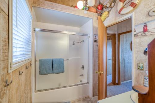 a bathroom with a shower with a blue towel at Nestle Inn - Meredith Lodging in Neskowin