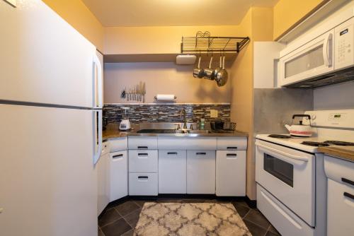 a kitchen with white cabinets and a white refrigerator at Georgetown Villas 2-1b Ideal for long stays! in Fairview Park