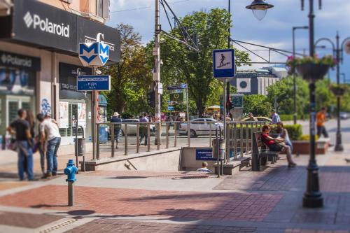 Eine belebte Stadtstraße mit Leuten, die laufen und ein blauer Hydrant. in der Unterkunft St. George Hotel in Sofia