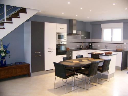 une cuisine avec une table et des chaises dans une cuisine dans l'établissement Gites Bellevue, à Beauvoir