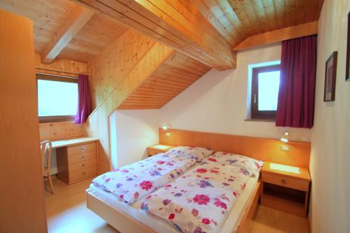 ein Schlafzimmer mit einem Bett und einer Holzdecke in der Unterkunft Apartment an der Aue in Steinhaus