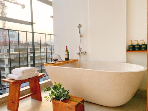 a bath tub in a room with a large window at 22Land Hotel & Residence in Hanoi
