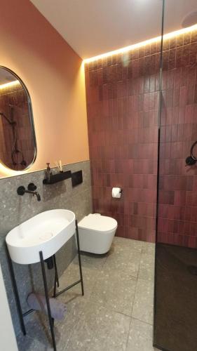 a bathroom with a sink and a toilet and a shower at w lesie in Skrwilno