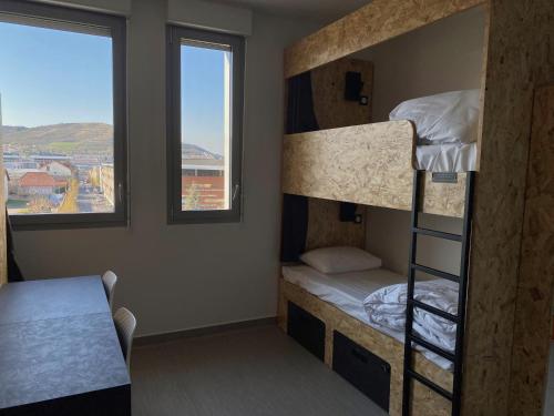 Cette chambre comprend 2 lits superposés et une fenêtre. dans l'établissement Auberge de jeunesse HI Clermont-Ferrand, à Clermont-Ferrand