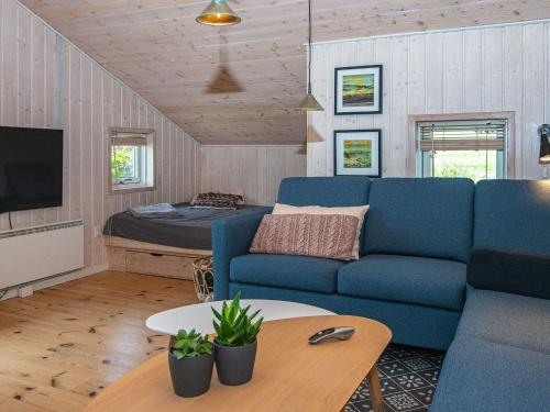 a living room with a blue couch and a bed at Holiday home Silkeborg XIX in Silkeborg
