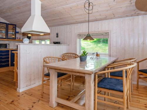 a kitchen and dining room with a wooden table and chairs at Holiday home Silkeborg XIX in Silkeborg