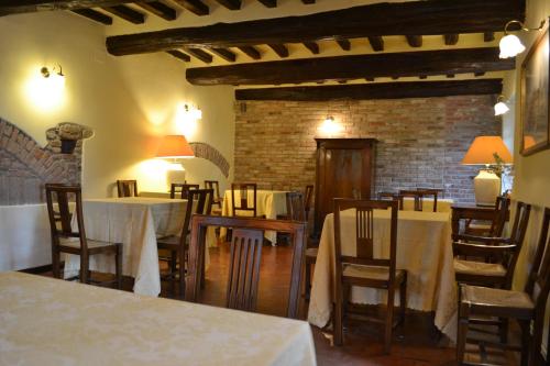a restaurant with tables and chairs and a brick wall at Hotel Torre di San Martino in Gazzola Di Rivalta