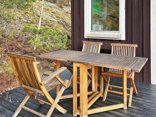 una mesa de madera y 2 sillas en el porche en Holiday home TYRESÖ V en Tyresö