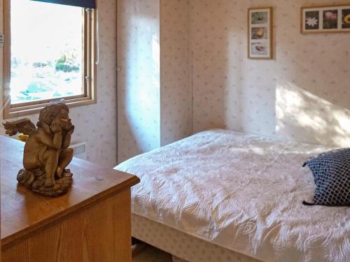 um quarto com uma cama e uma estátua sobre uma mesa em Holiday home NORRTÄLJE IX em Norrtälje