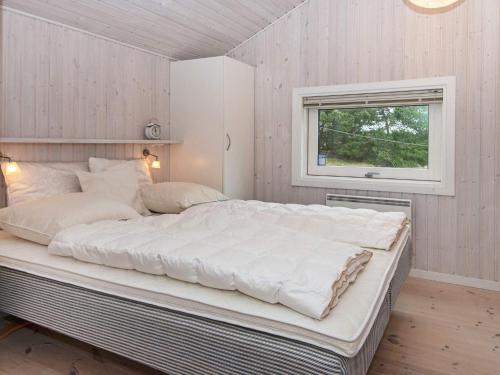 a large white bed in a room with a window at Holiday home Fanø CCVI in Fanø