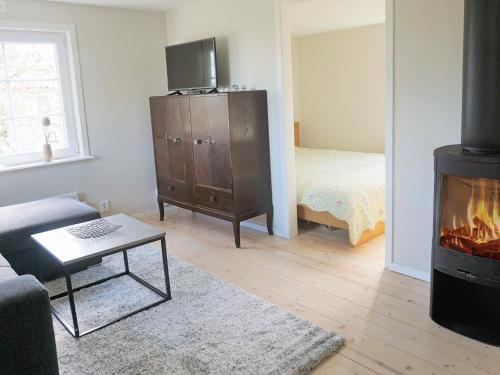 a living room with a fireplace and a bedroom at 5 person holiday home in SÖLVESBORG-By Traum in Sölvesborg