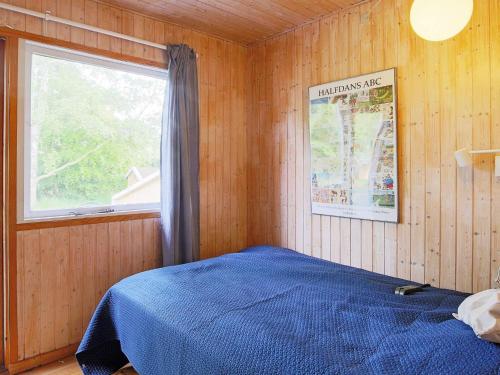 Un dormitorio con una cama azul y una ventana en Holiday home Højby XXXIII, en Højby